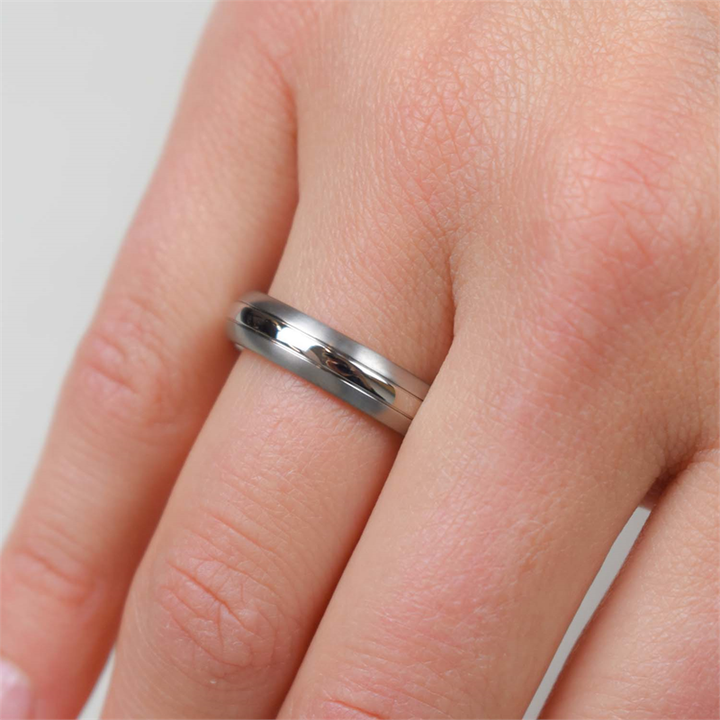 Een close-up van een hand met de Boccia Titanium Ring 0131-01 van Boccia aan de ringvinger tegen een lichte achtergrond.