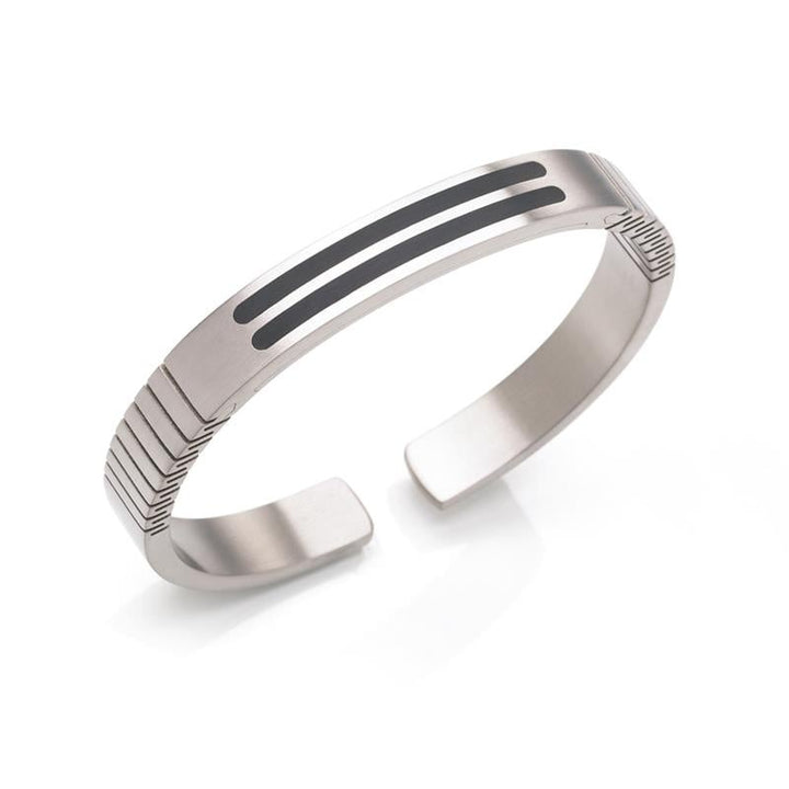 De Boccia Titanium Armband Spang emaille 0340-02 van Boccia is een strakke, zilverkleurige klemarmband met twee parallelle zwarte emaille accenten en gegraveerde horizontale groeven bij de open uiteinden, afgebeeld op een witte achtergrond.