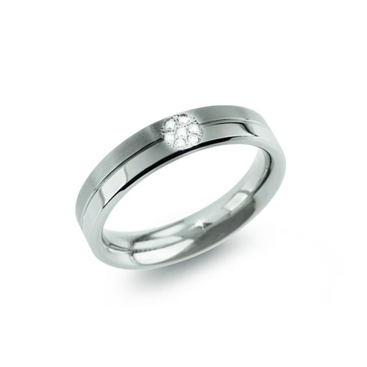 De Boccia Titanium Ring dia 7/0.035 - 0129-05 van Boccia heeft een slanke titanium band met een delicaat cluster van ronde witte diamanten in een bloempatroon in het midden, tegen een witte achtergrond.