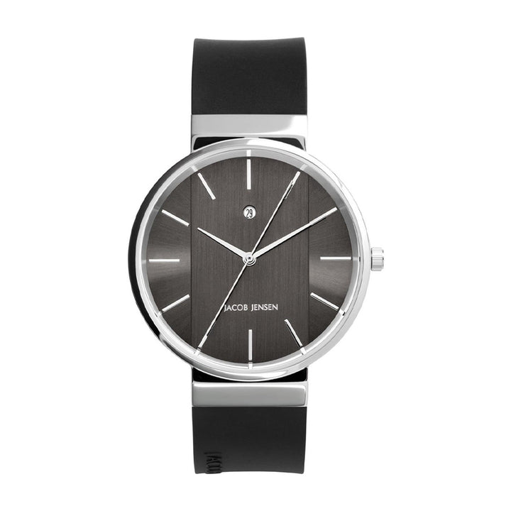 Het Jacob Jensen 708 polshorloge heeft een strak zwart rond gezicht met minimalistische witte markeringen en wijzers. De zilveren kast combineert elegant met de zwarte band en de quartz wijzerplaat is versierd met Jacob Jensen.