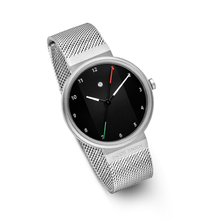 Maak kennis met de Jacob Jensen 780: een minimalistisch quartzhorloge met een zwarte wijzerplaat, slanke witte wijzers en een veelkleurige secondewijzer. Omhuld door roestvrij staal, heeft het een zilveren meshband voor tijdloze elegantie.