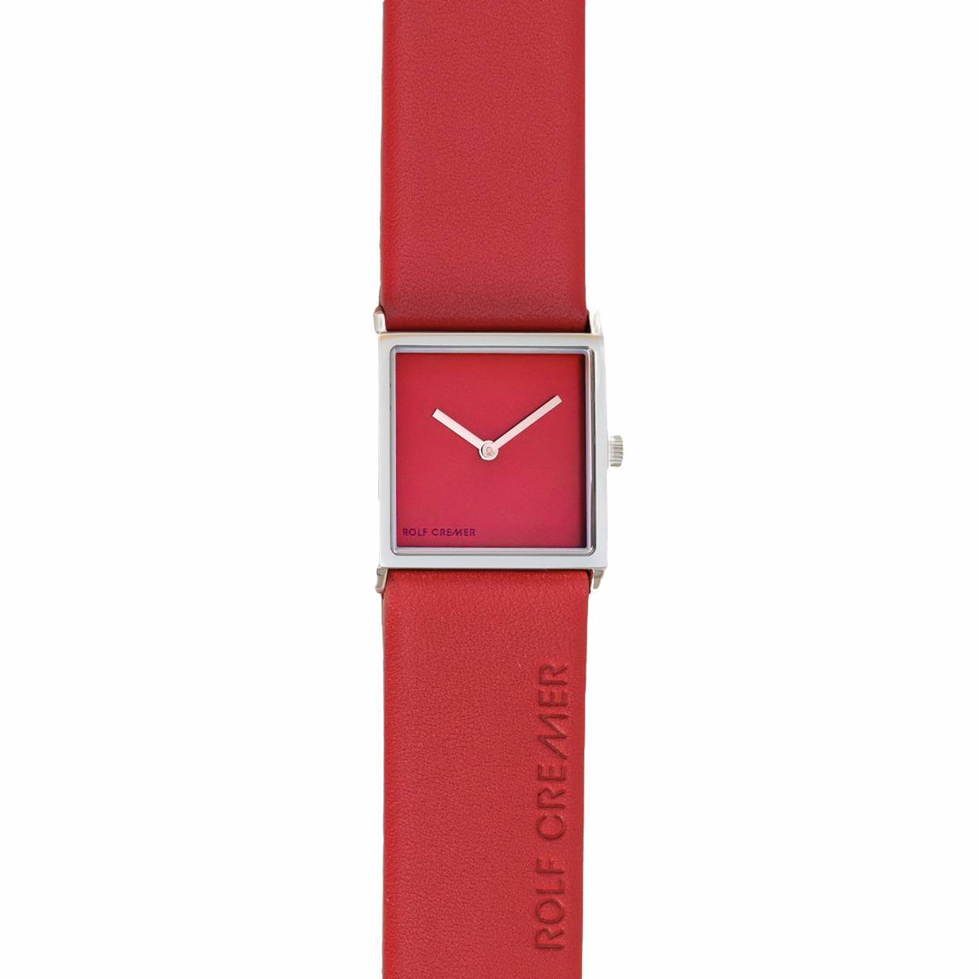 Het Rolf Cremer Horloge 508206 is een strak horloge met een vierkante wijzerplaat, een rode wijzerplaat, twee zilveren wijzers en een zilverkleurige kast. Het heeft een rode leren band met de gravure Rolf Cremer en loopt op betrouwbaar quartz uurwerk. Dit elegante herenhorloge is een voorbeeld van minimalistisch design.