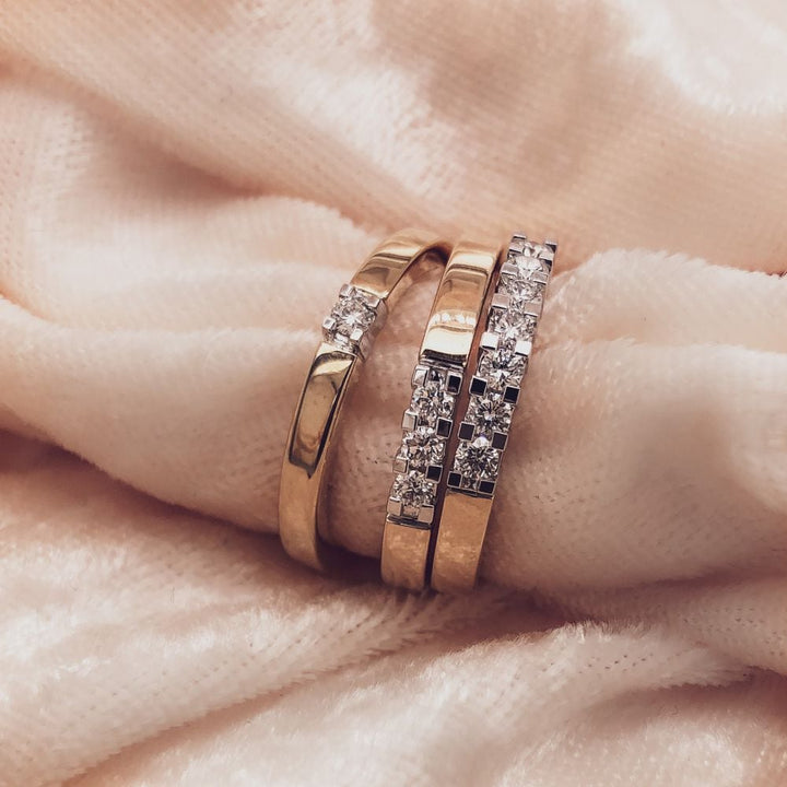 De Slanke Bicolor Gouden Ring met Briljant Diamant 0.35 crt. van Excellent Jewelry rust op zacht blush stof, waardoor een elegante en luxueuze display ontstaat.