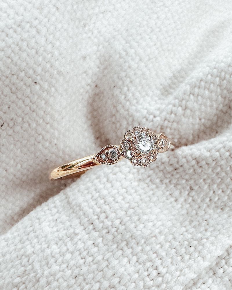 De Verfijnde Geelgouden Ring met Briljant Geslepen Middensteen 0.21 crt. van Excellent Jewelry is een elegante 14 karaat geelgouden ring met een ronde centrale diamant, gefotografeerd op crèmekleurige stof.