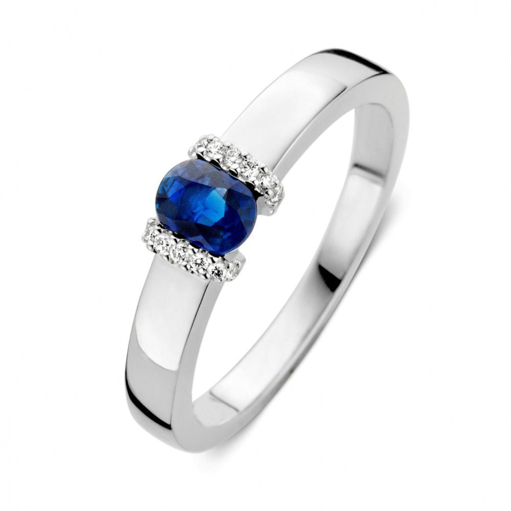 Ring aus Weißgold mit blauem Saphir und Diamanten, schlichte Form und glänzende Oberfläche