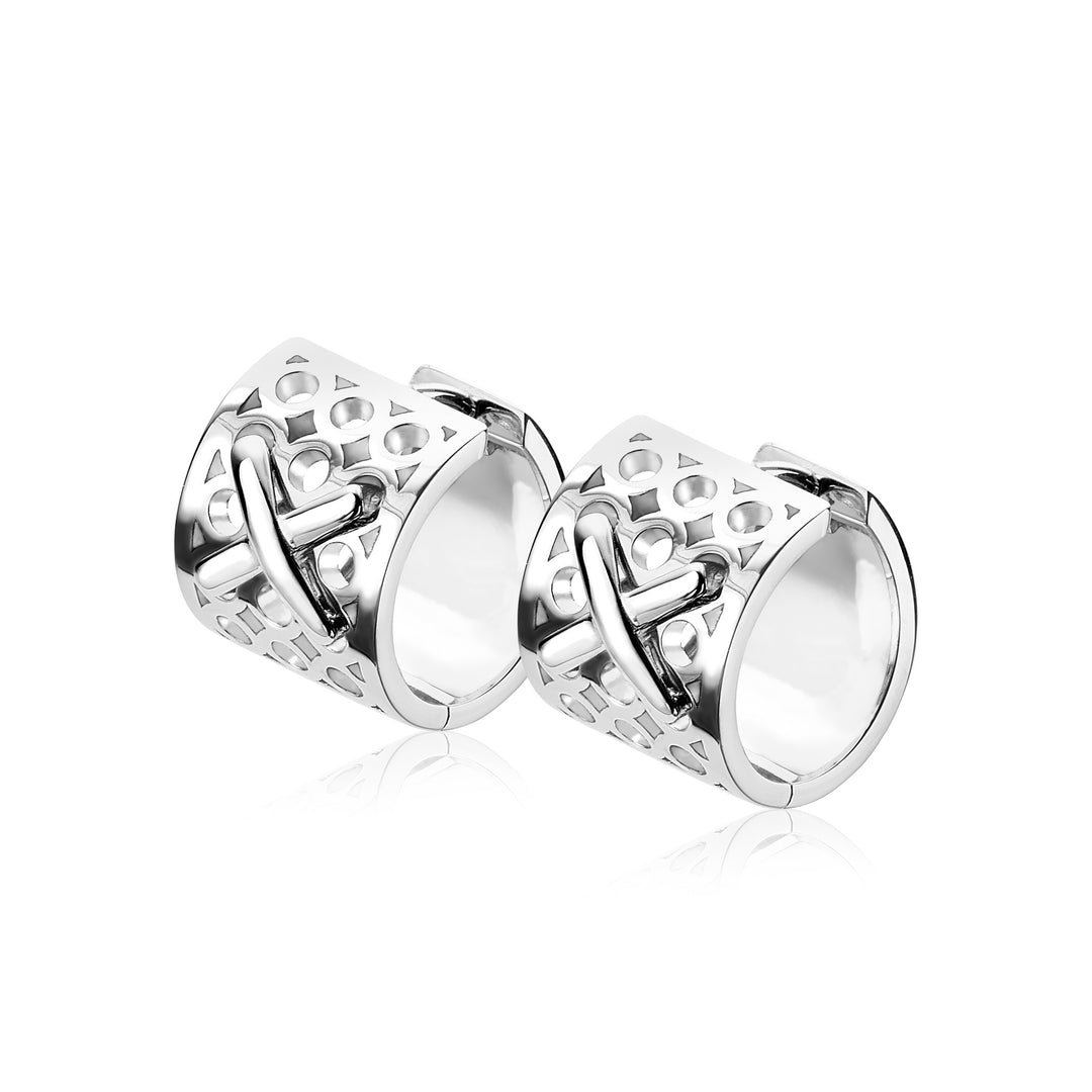 Twee zilveren cilindrische Zinzi oorbellen (Zilver Mvo15) hebben hartvormige uitsparingen en een kruislings ontwerp. Hun glanzende oppervlak reflecteert licht voor een gepolijste look, waarbij elegantie en charme in elk detail worden vastgelegd.