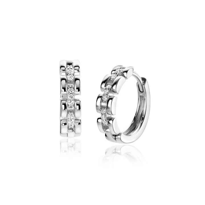 De Zinzi Oorbellen Zilver ZIO2504 van Zinzi zijn zilveren oorbellen met een centrale rij fonkelende witte zirkonia's en decoratieve accenten aan de zijkant, afgebeeld op een witte achtergrond.