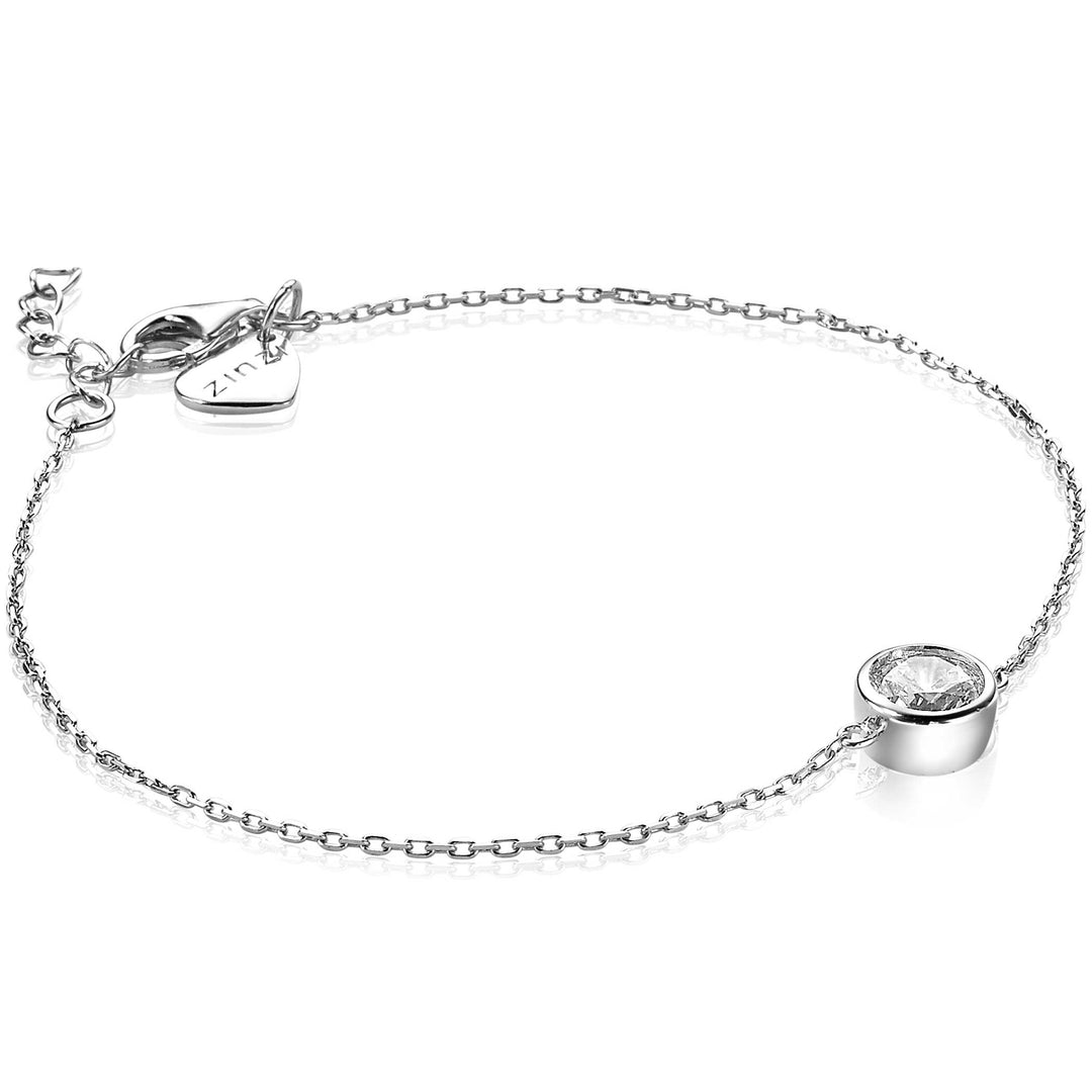 De Zinzi Armband Zilver Zia1775 heeft een elegant, minimalistisch design met een delicate zilveren ketting, een ronde heldere edelsteen in een bezelzetting, een verstelbare sluiting en een klein hartje. Perfect voor elke gelegenheid.