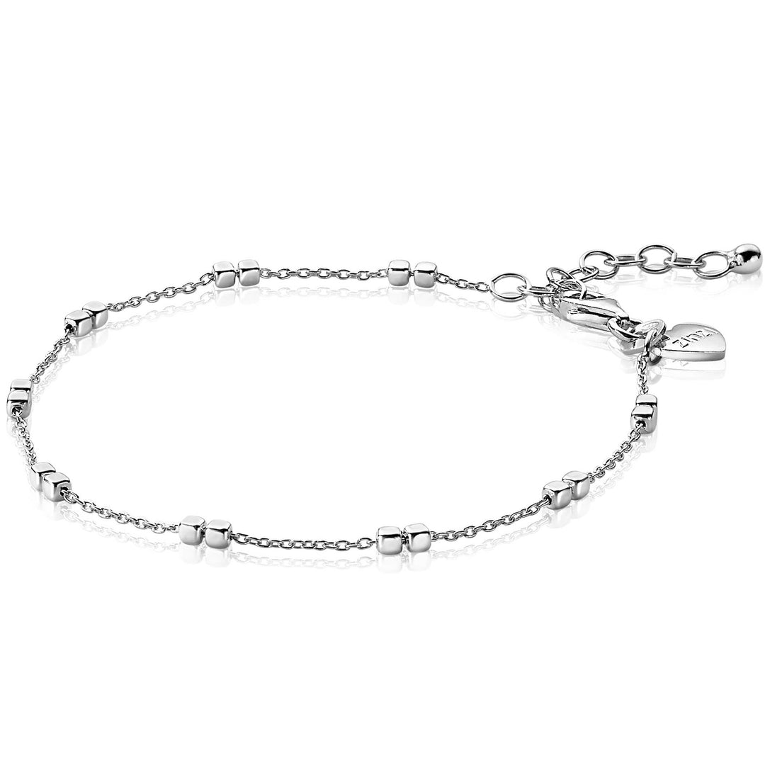 De Zinzi Armband Zilver Zia2218 is een delicate zilveren schakelarmband met gelijkmatig verdeelde kleine ronde kraaltjes, een verstelbare sluiting, een verlengketting en een hartvormig bedeltje bij de sluiting. Deze armband voegt elegantie toe aan elke sieradencollectie.