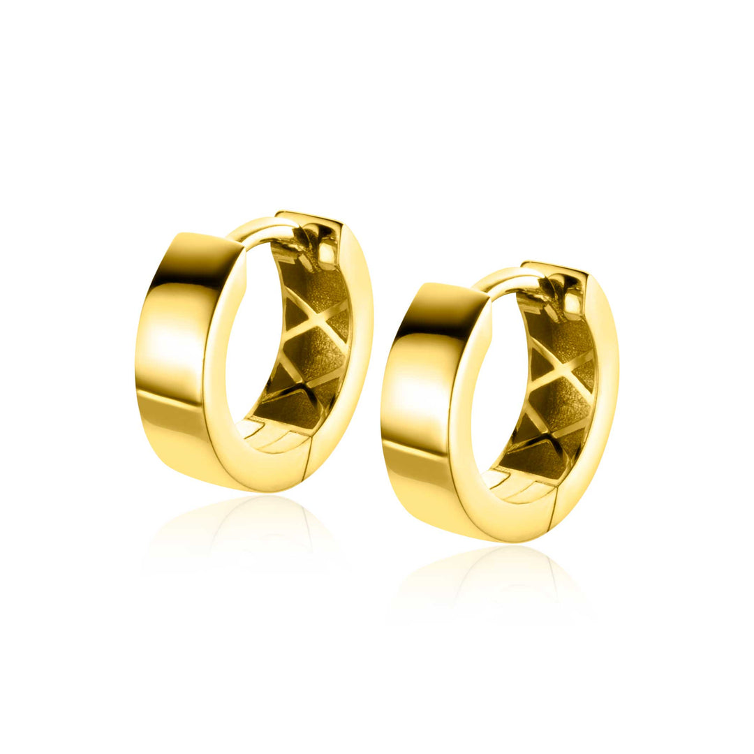 De Zinzi Oorbellen Goud Zgo438 is een paar glanzende gouden creolen met een gladde, gepolijste afwerking en luxe klapsluiting. Hun klassieke ronde vorm reflecteert licht, waardoor hun glanzende oppervlak wordt benadrukt. Deze oorbellen zijn echt betoverend, afgezet tegen een witte achtergrond.