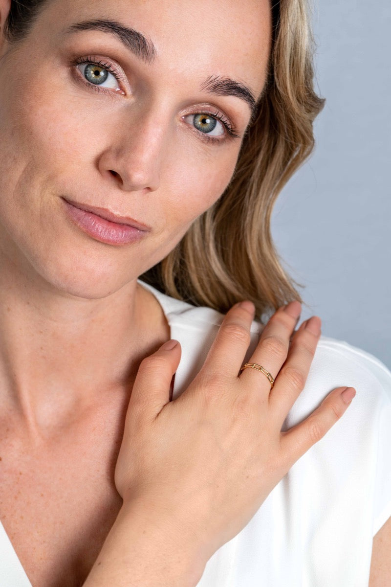 Goldener Ring mit feiner Struktur, getragen an der Hand einer Frau