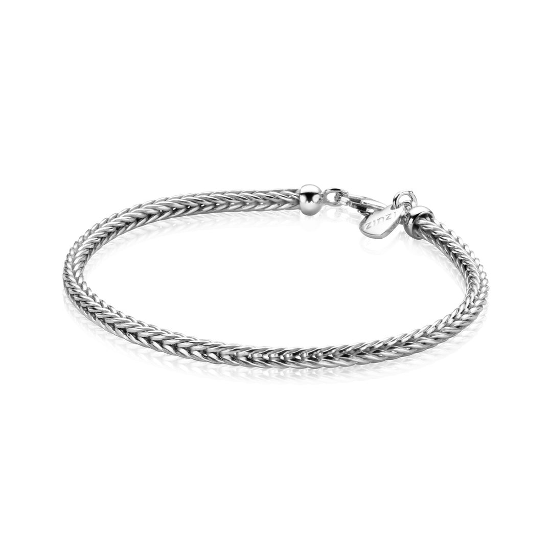 De Zinzi Armband Zilver Zia1124 van Zinzi is een strakke, zilverkleurige armband met een geweven touwontwerp en een klein rond label bij de sluiting, die elegantie uitstraalt tegen de witte achtergrond.